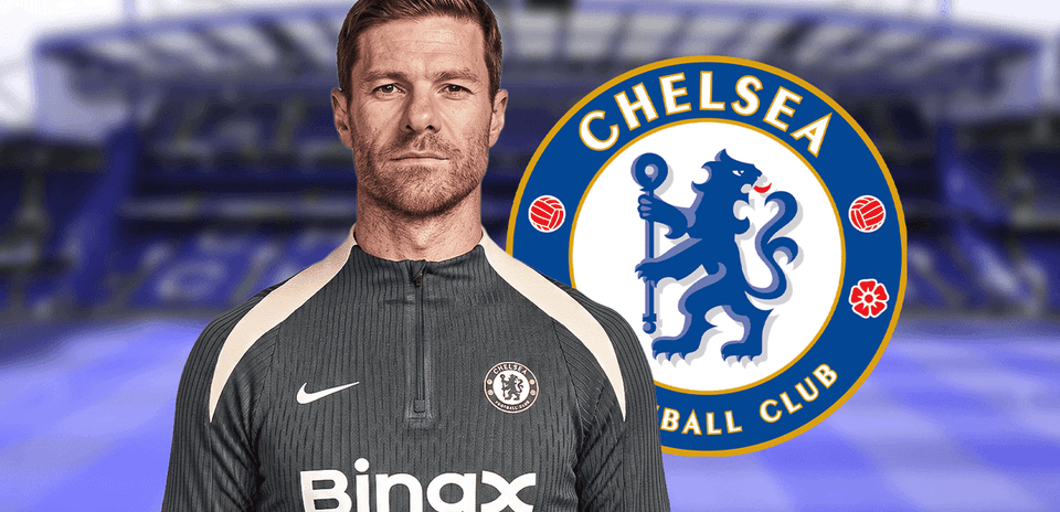 Entrenador de Chelsea posando frente al logo del club