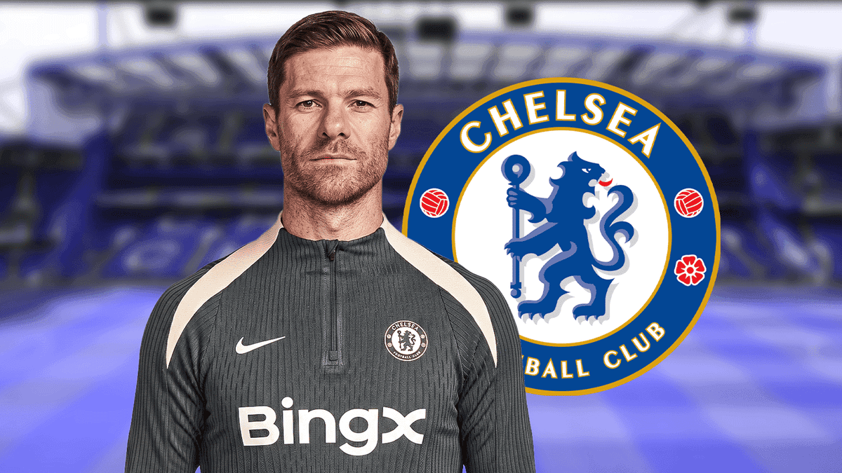 Entrenador de Chelsea posando frente al logo del club