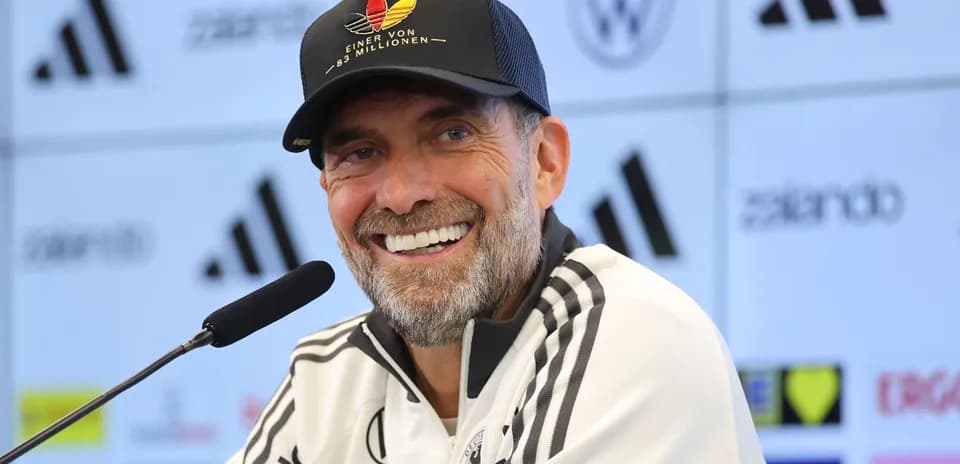 Entrenador en conferencia de prensa sonriente