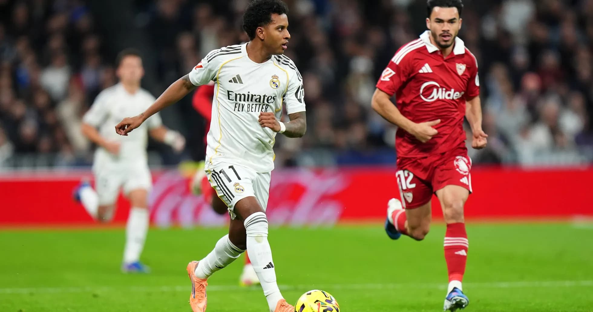 Jugador de Real Madrid driblando a rival de Sevilla