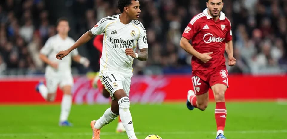 Jugador de Real Madrid driblando a rival de Sevilla