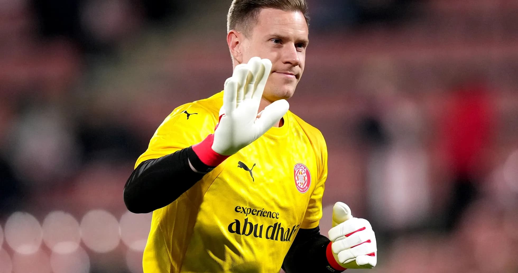 Portero saludando con guantes en uniforme amarillo