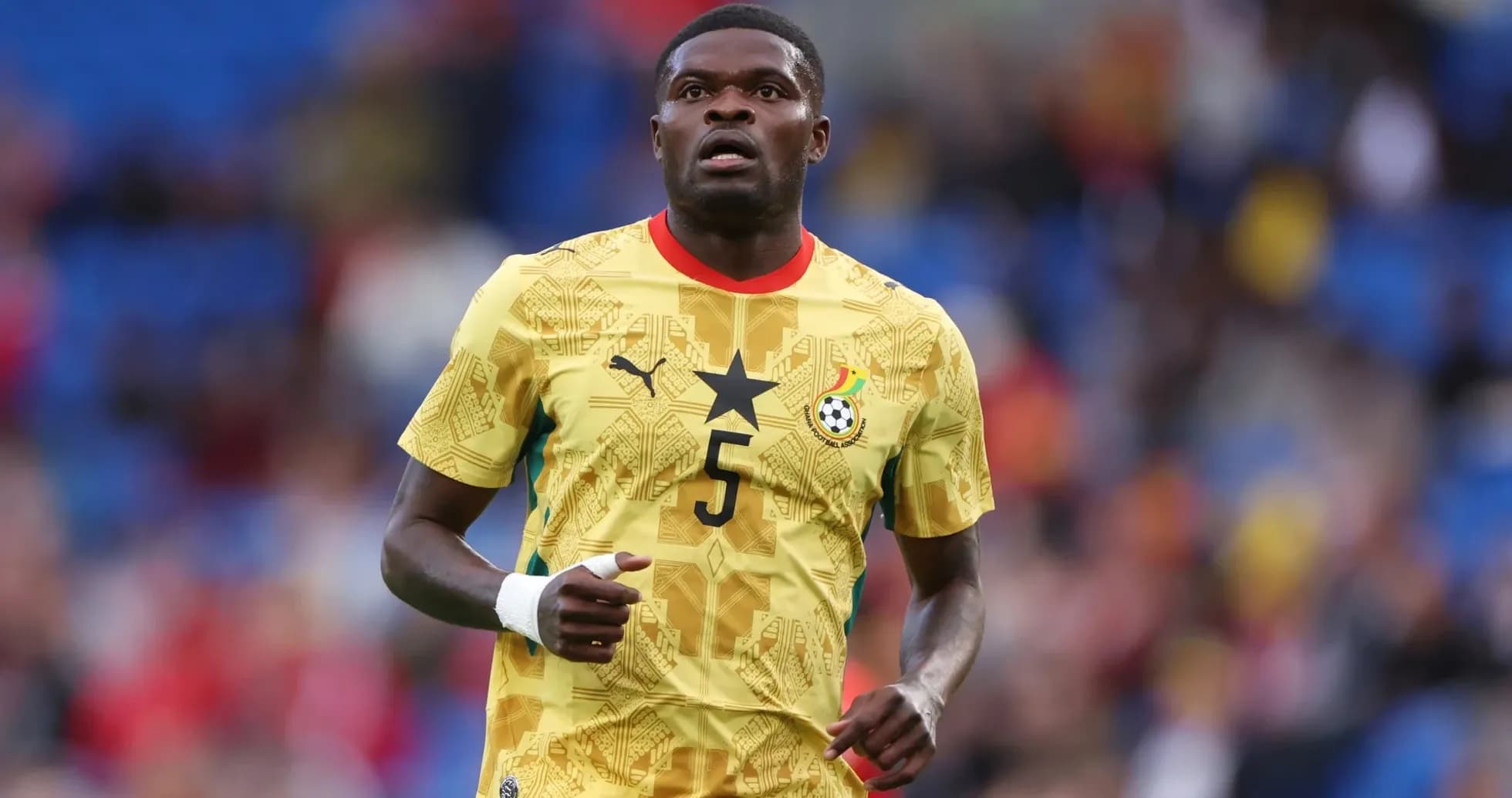 Jugador de Ghana corriendo en camiseta amarilla