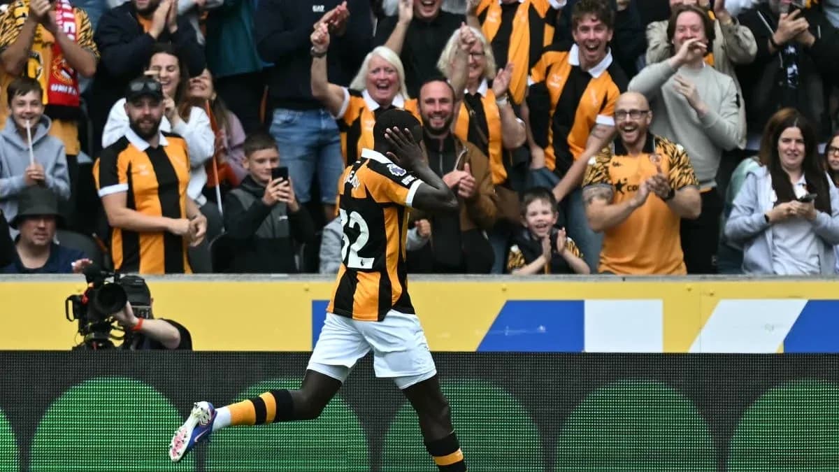 Jugador celebrando un gol frente a aficionados animando