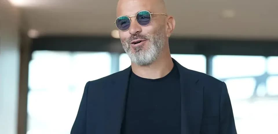 Hombre con gafas de sol sonriendo en interior
