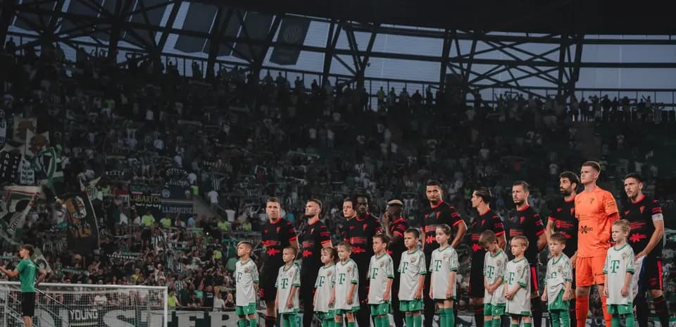 Jugadores de Ferencvarosi y niños en el campo