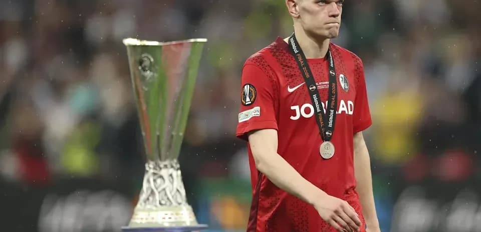 Jugador con medalla, caminando junto al trofeo