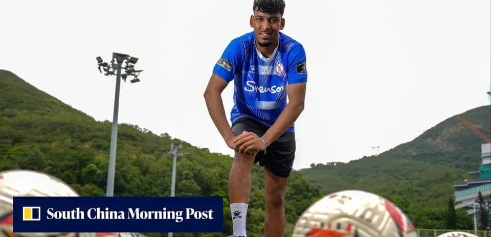 Jugador posando con balones en campo de entrenamiento