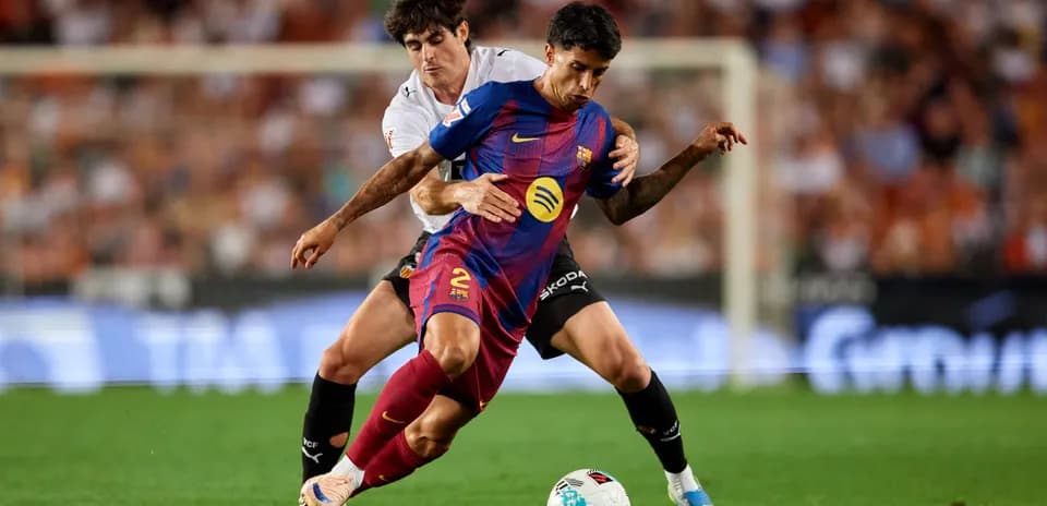 Jugador de Barcelona luchando por el balón con oponente