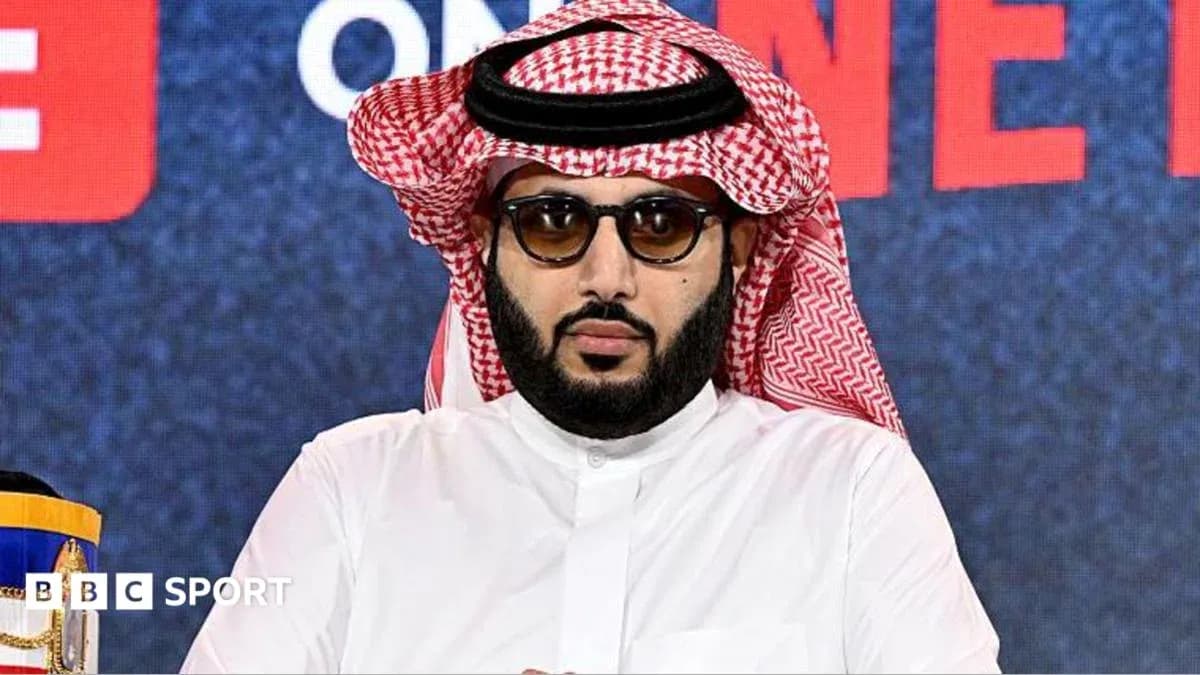 Persona en conferencia de prensa con gafas y atuendo tradicional