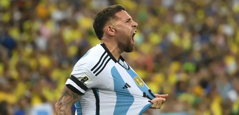 Jugador argentino celebrando en partido con afición detrás