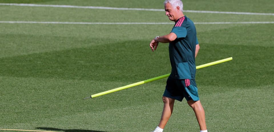 Entrenador caminando con varilla en el campo de entrenamiento