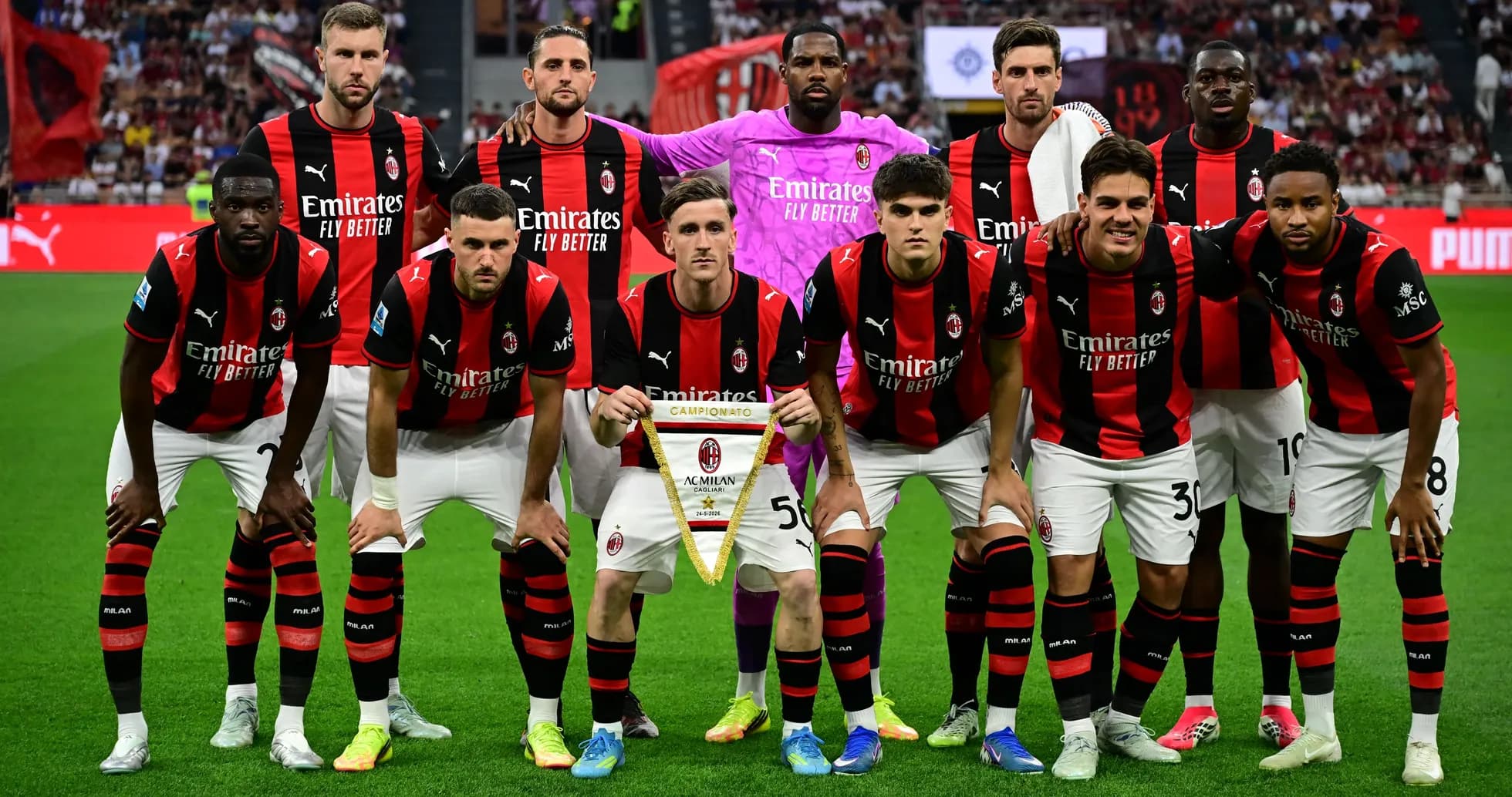 Equipo de AC Milan posando con trofeo en el campo