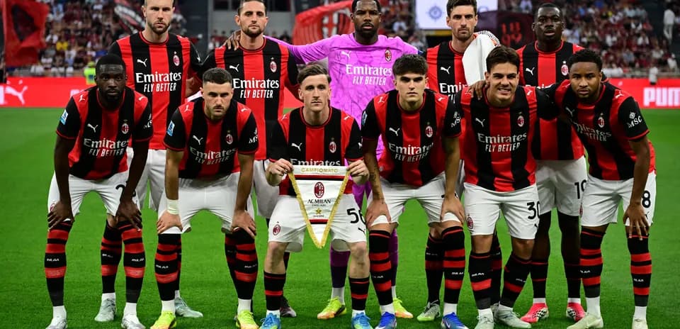 Equipo de AC Milan posando con trofeo en el campo