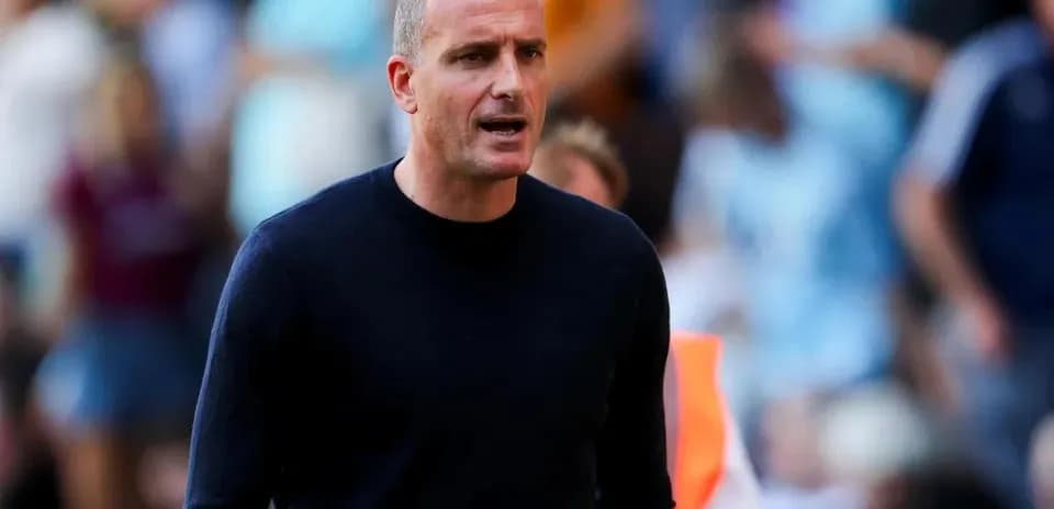 Entrenador dirigiendo desde la línea de banda