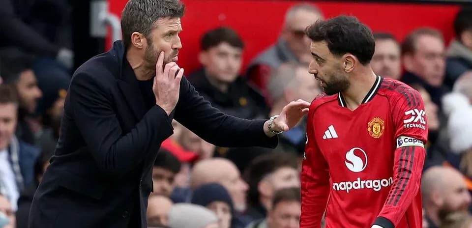Entrenador dando instrucciones a jugador de Manchester United