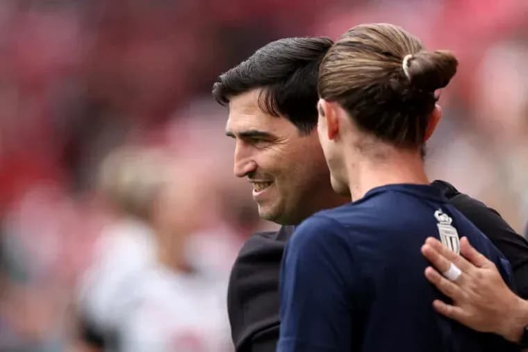 Entrenador y jugador intercambiando saludos en el campo