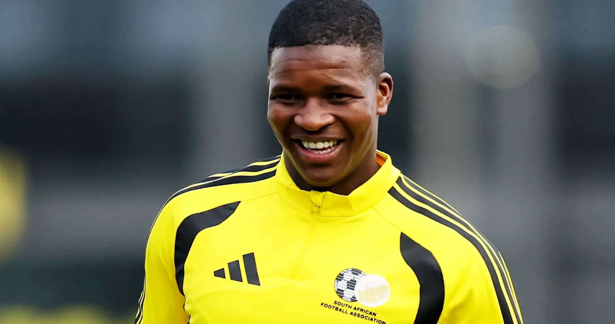Jugador sonriente en entrenamiento con camiseta amarilla