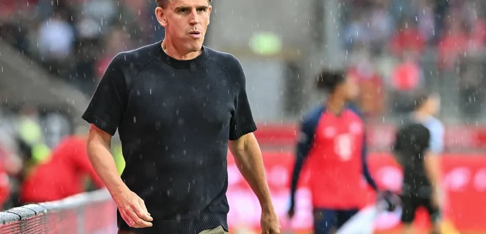 Entrenador caminando en campo bajo la lluvia