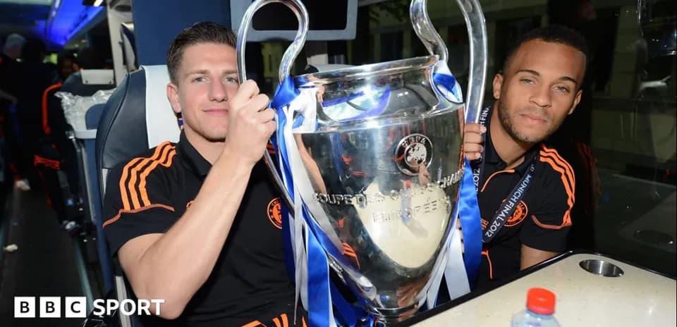 Jugadores sosteniendo la Copa de la UEFA en autobús