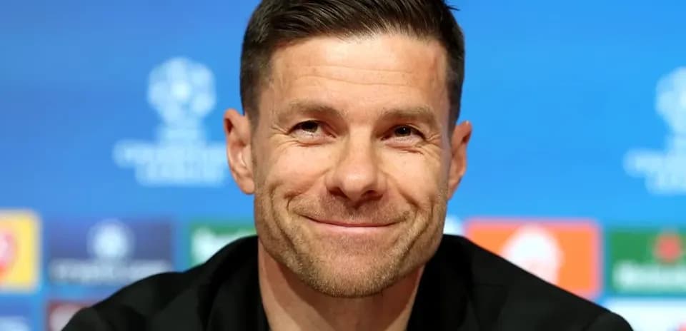 Entrenador en rueda de prensa sonriendo