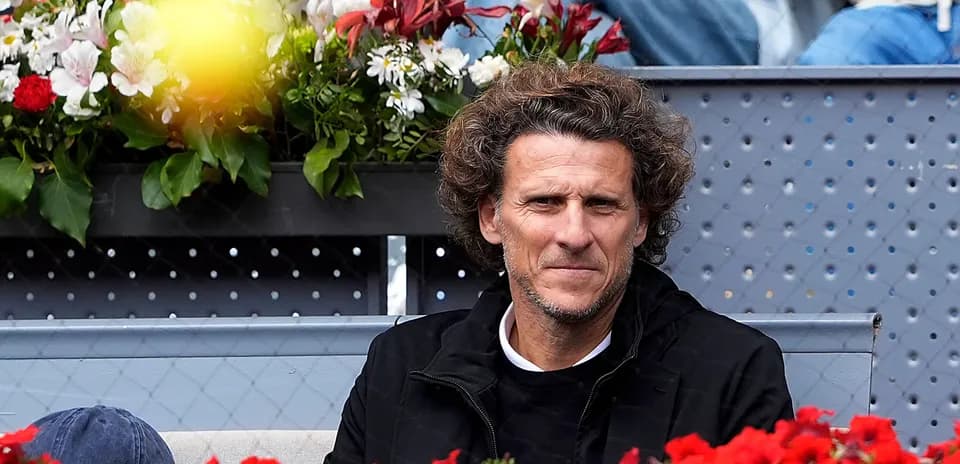 Hombre sentado en gradas con flores alrededor