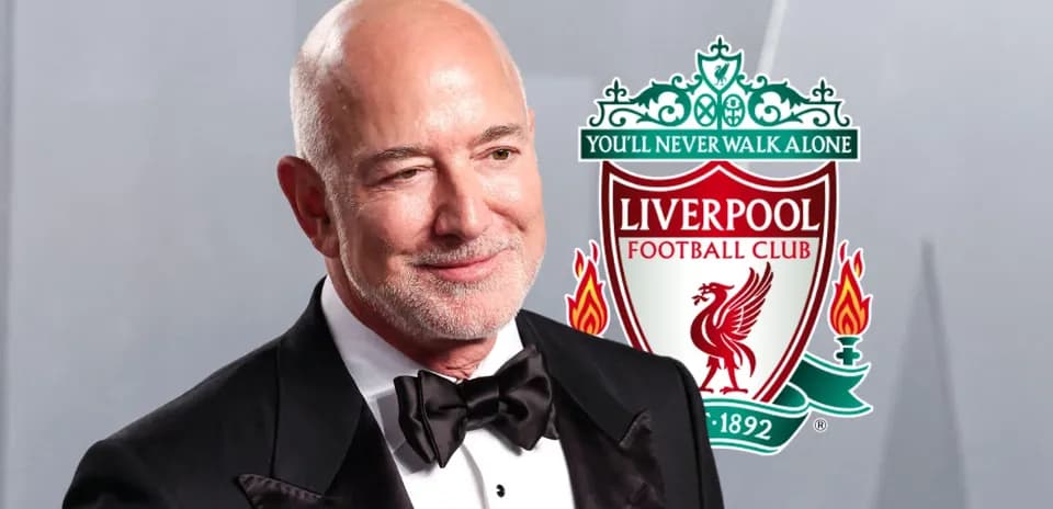 Hombre sonriendo con logo de Liverpool detrás