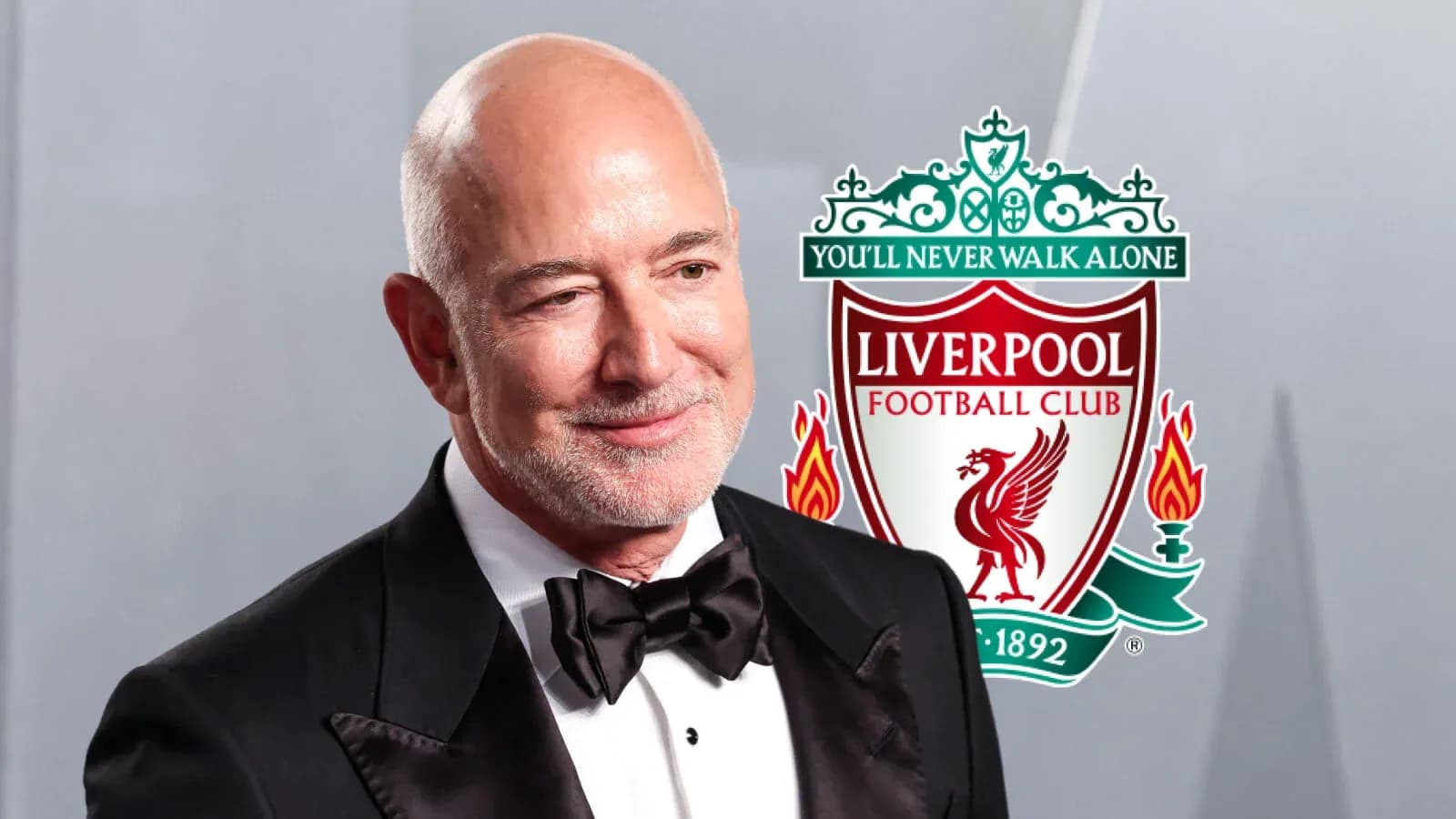 Hombre sonriendo con logo de Liverpool detrás