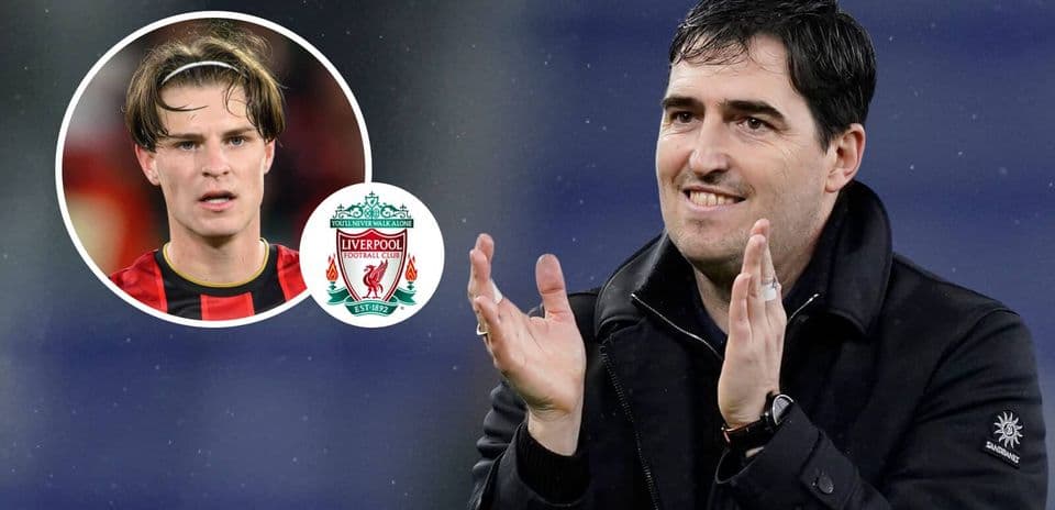 Entrenador aplaudiendo con jugador y logo de Liverpool