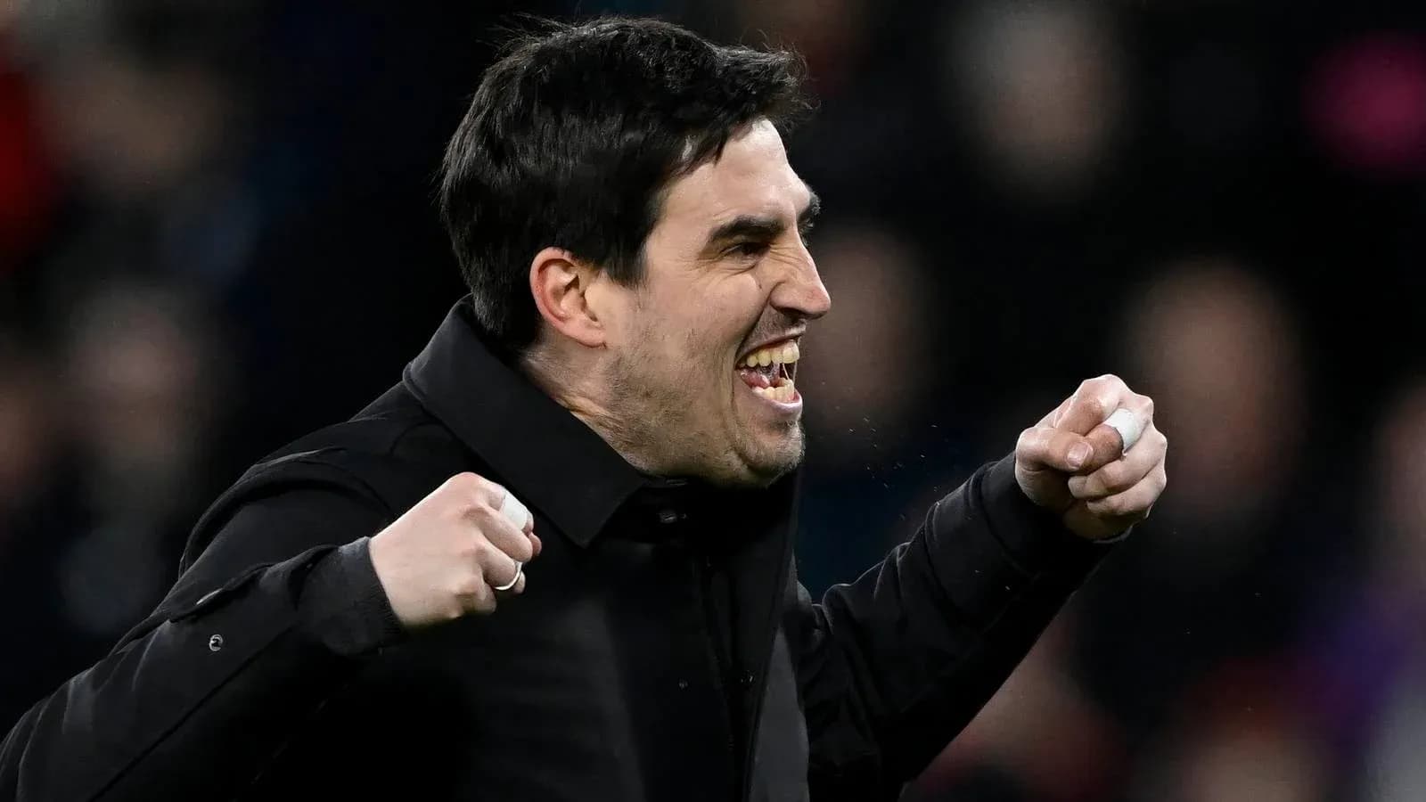 Entrenador celebrando una victoria con los puños en alto