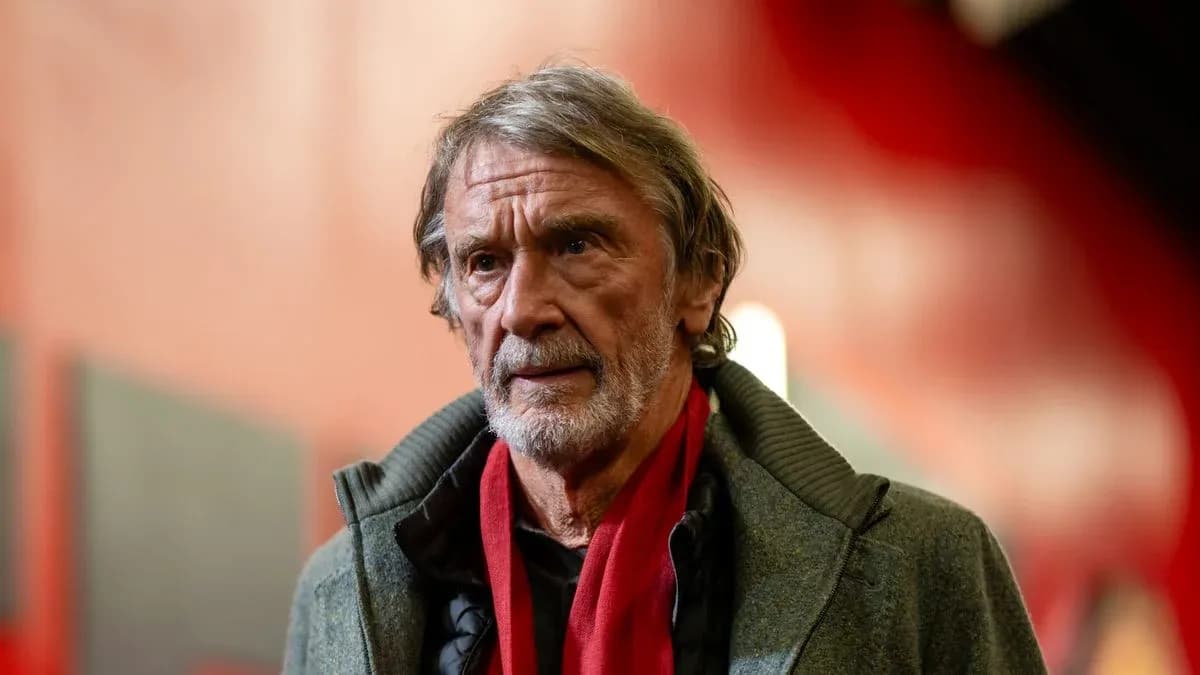 Hombre mayor con abrigo y bufanda roja en pasillo