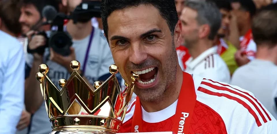 Entrenador de Arsenal celebrando con trofeo de liga