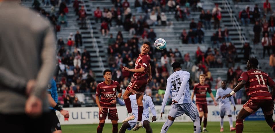 Jugador saltando para cabecear el balón en partido