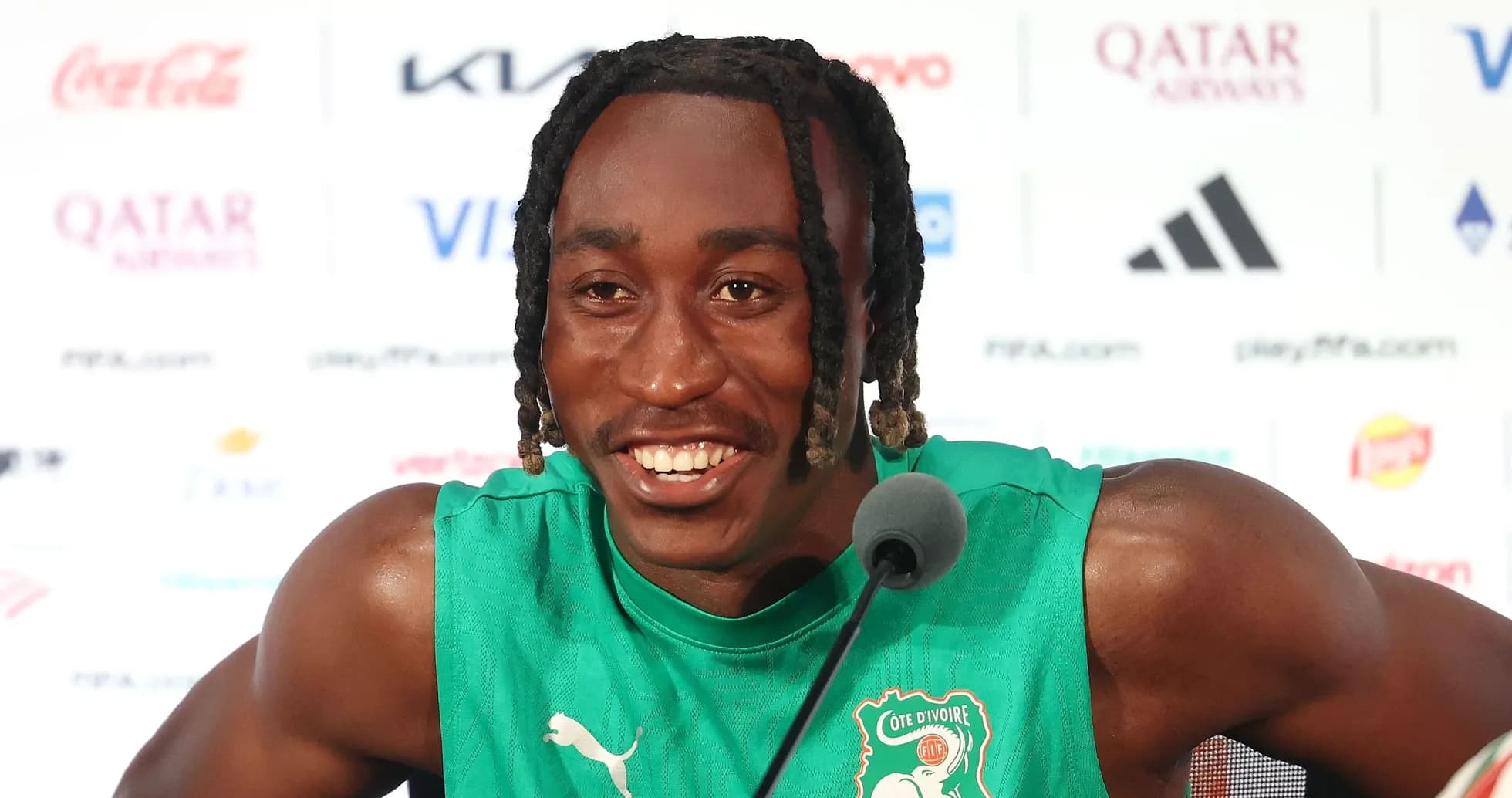 Jugador de fútbol en conferencia de prensa sonriente