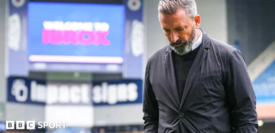 Entrenador caminando en Ibrox Stadium con mirada seria