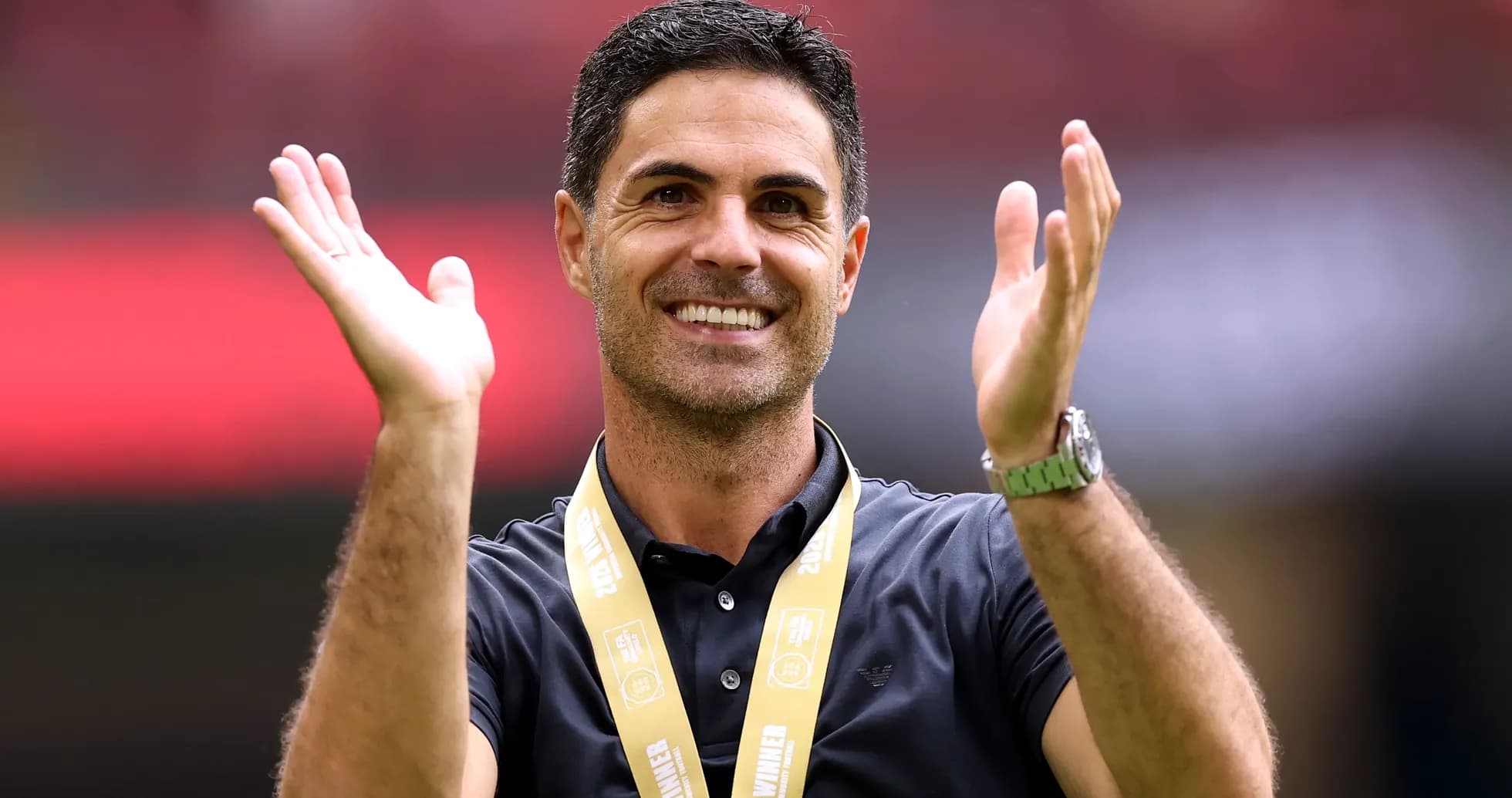 Entrenador aplaudiendo con medalla de campeón