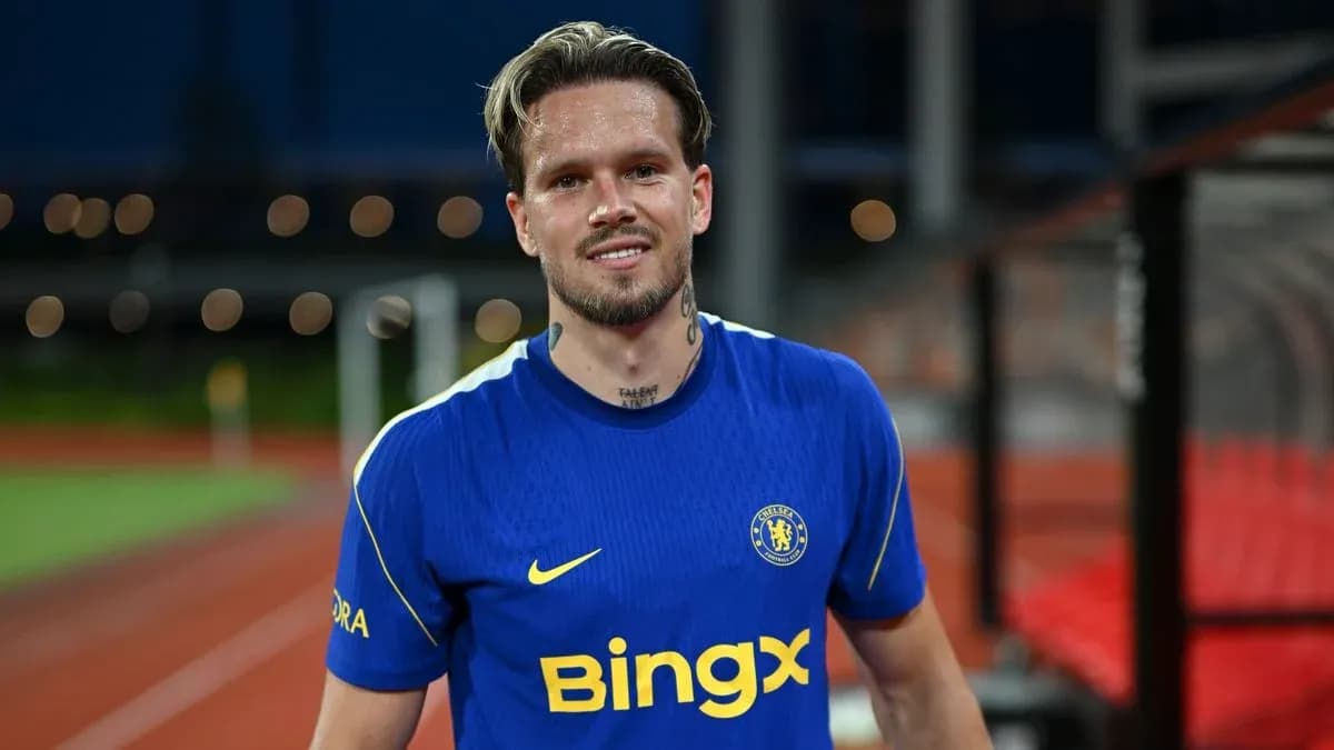 Jugador sonriente con camiseta de Chelsea en el campo