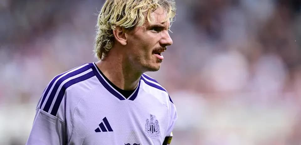 Jugador de Newcastle con camiseta morada en el campo