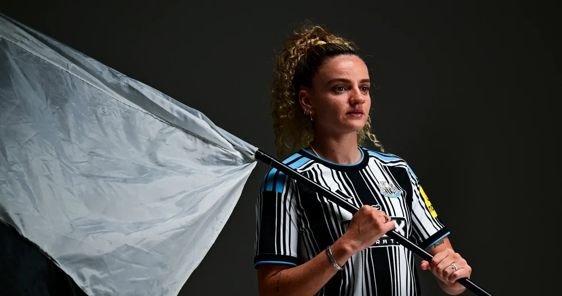 Jugadora sosteniendo una bandera en sesión fotográfica
