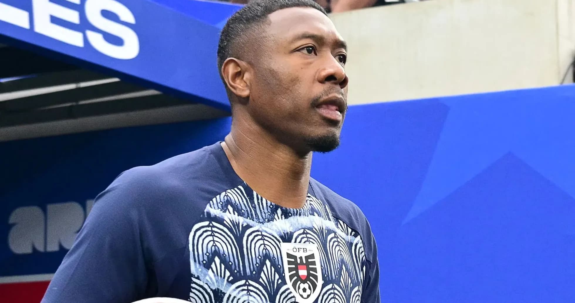 Jugador entrando al campo con balón en mano