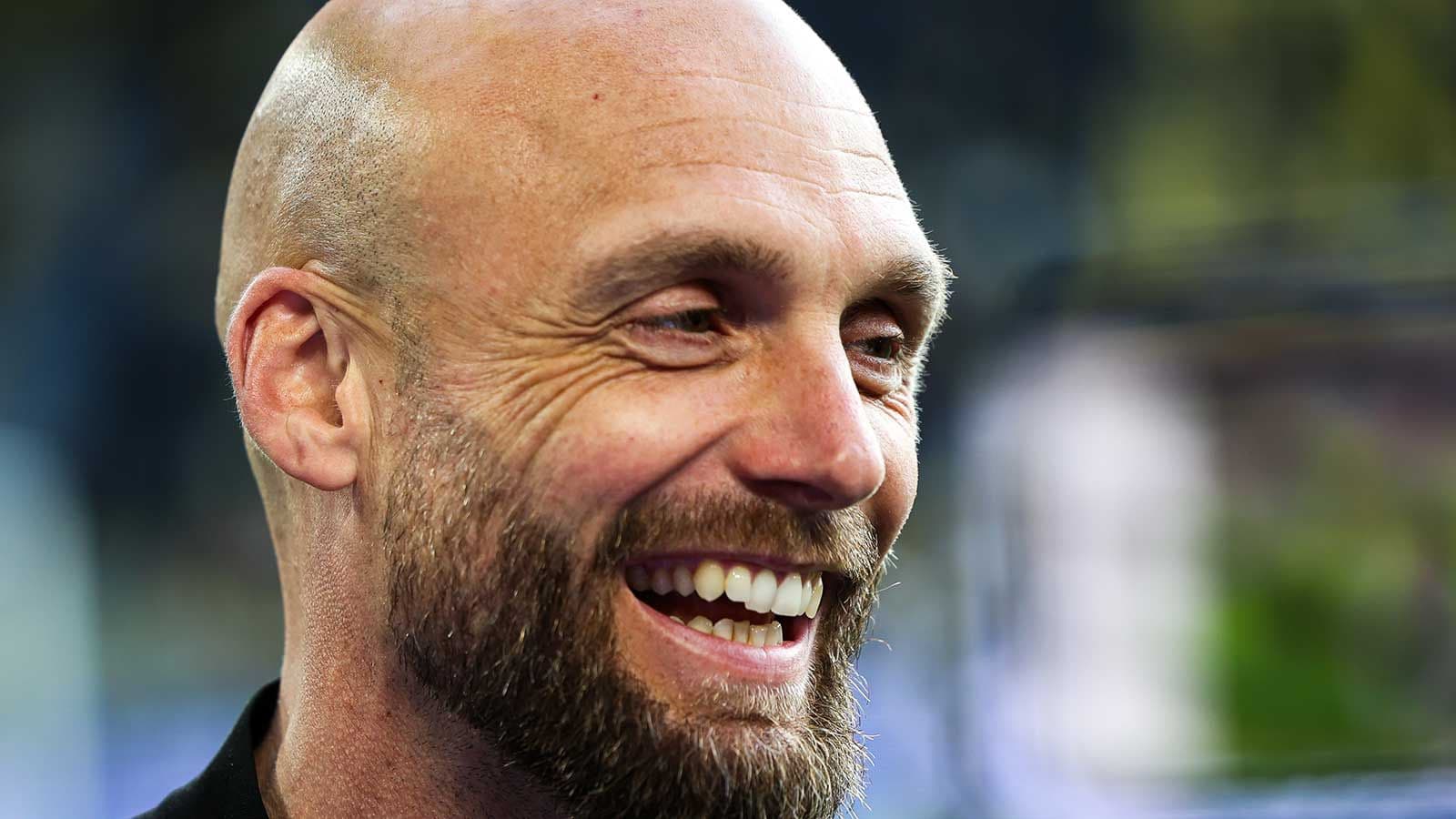 Entrenador sonriendo durante una entrevista