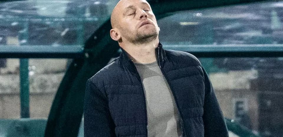 Entrenador en la banca con expresión de frustración