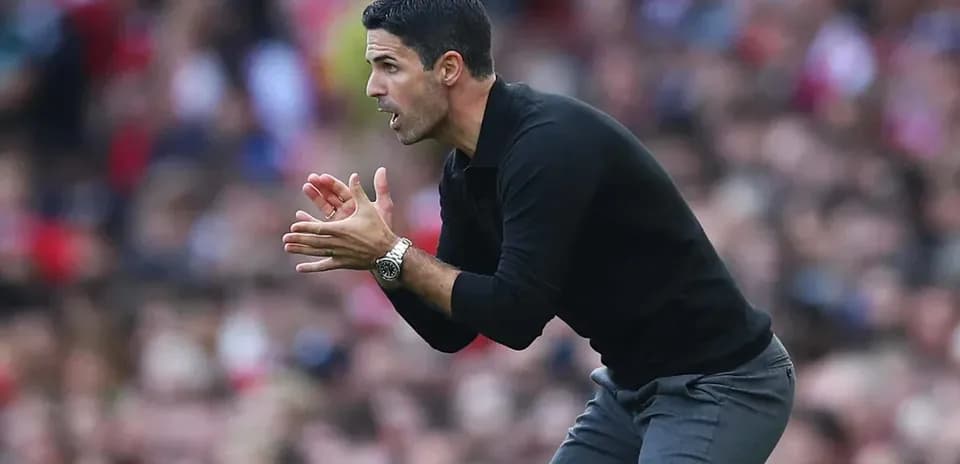 Entrenador dando instrucciones desde la banda del campo
