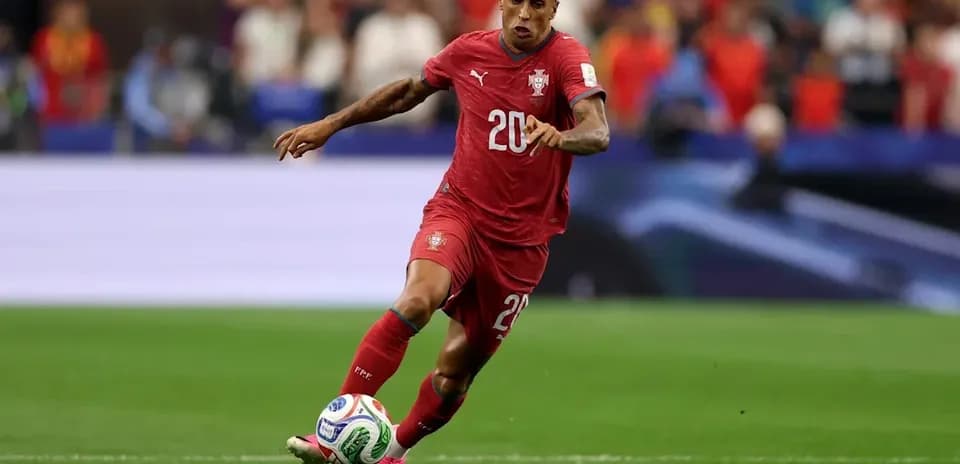 Jugador de Portugal corriendo con el balón en el campo