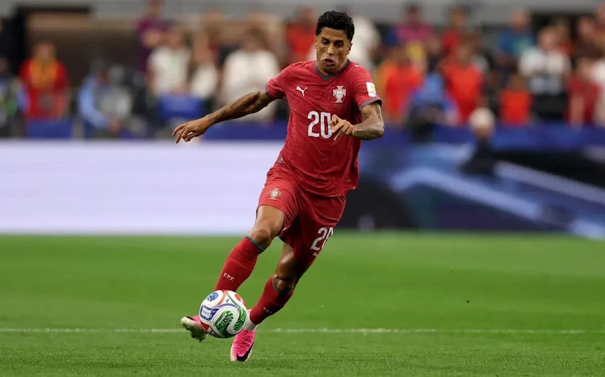 Jugador de Portugal corriendo con el balón en el campo