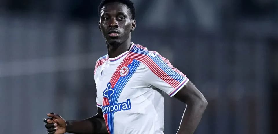 Jugador corriendo en uniforme de fútbol blanco y rojo