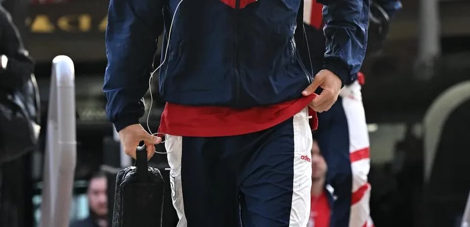 Jugador con traje de entrenamiento llegando al autobús