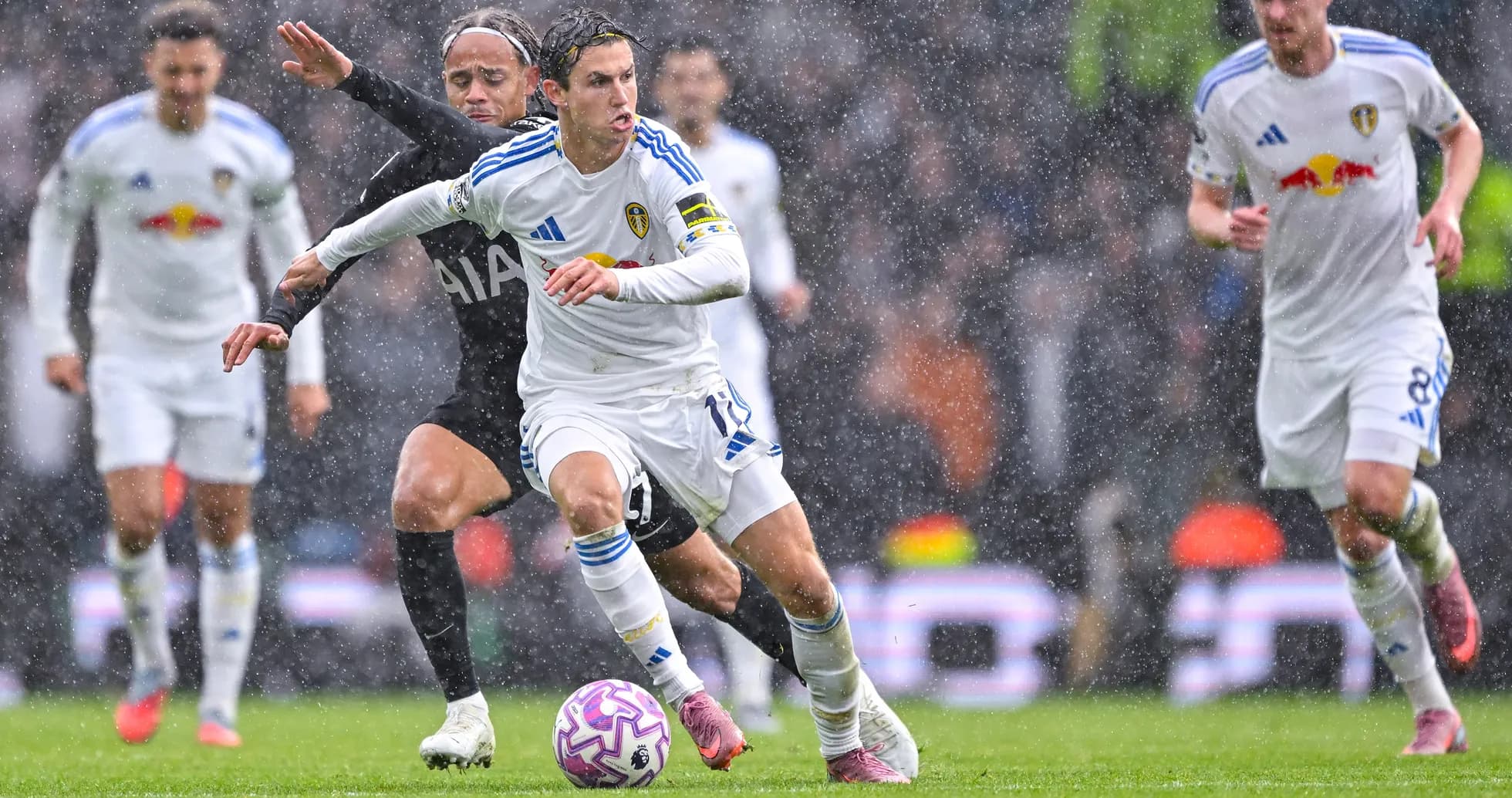Jugador de Leeds driblando bajo la lluvia