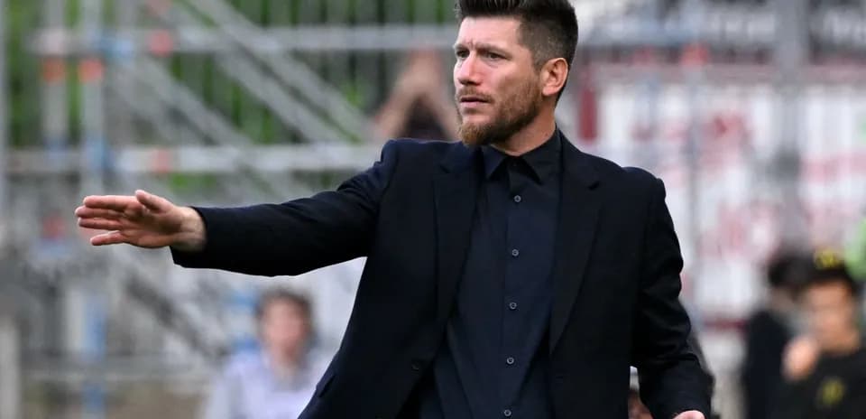 Entrenador dirigiendo desde la banda del campo