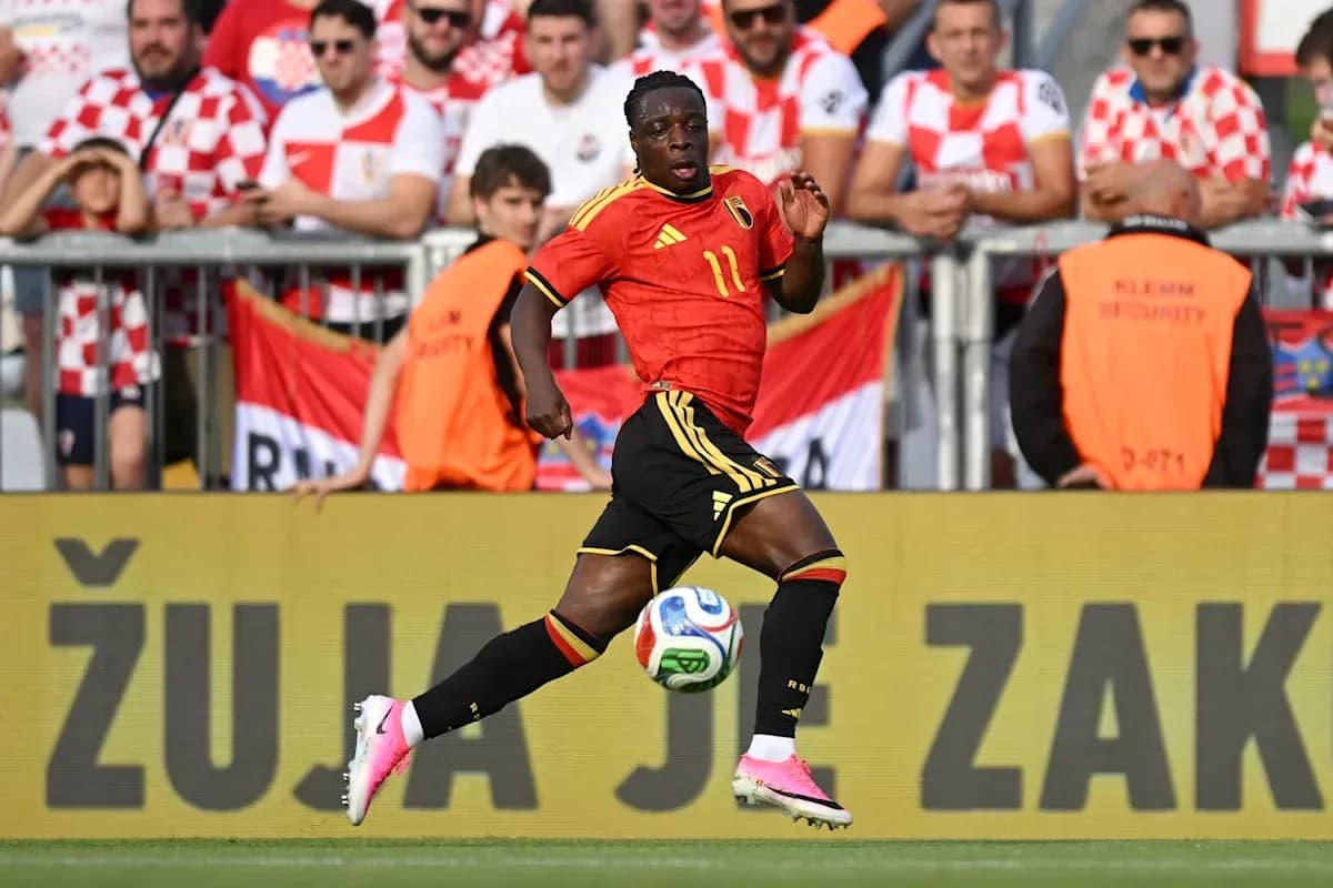 Jugador de Bélgica corriendo con balón en el campo